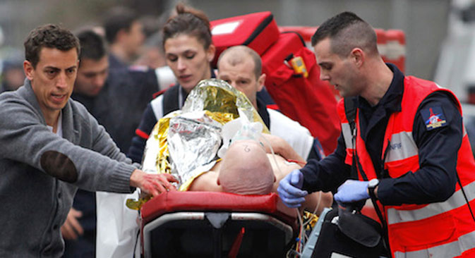 Des ambulanciers aident un blessé à la suite de la fusillade à Charlie Hebdo.  Crédit : AP
