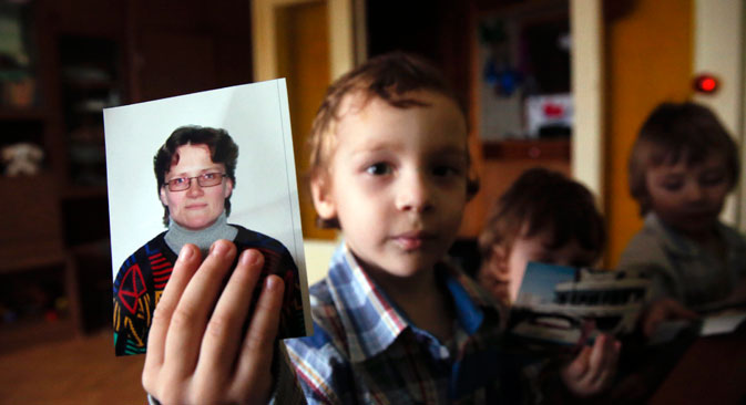 Un enfant de Svetlana Davydova tient la photo de sa mère. Crédit : Reuters