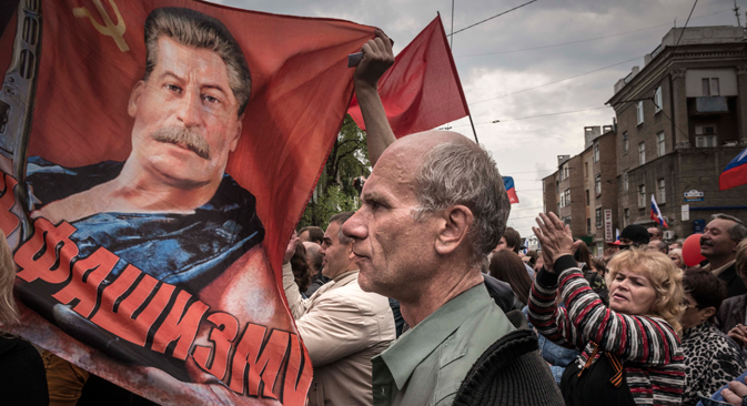 À Donetsk, le 1er mai 2014. Des manifestants avec des drapeaux soviétiques et un portrait de Joseph Staline participent au traditionnel défilé du 1er mai. Sergey Ponomarev pour New York Times