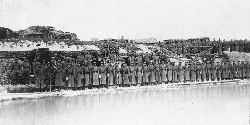 L’hiver 1916-17, une compagnie alignée devant ses positions, on remarque les cheminées des abris, avec un petit lac gelé qui s’est formé.
