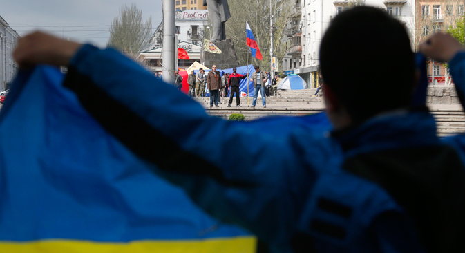 Proukrajinski pristaše stoje s ukrajinskom zastavom nasuprot proruskih pristaša u Donjecku, u istočnoj Ukrajini. Izvor: AP