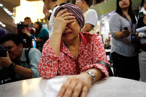 Seorang ibu menangis di Bandar Udara Internasional Kuala Lumpur seraya menunggu informasi mengenai jatuhnya peswat. Foto: Reuters