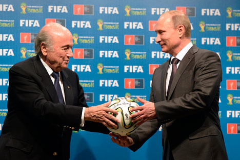 Presiden FIFA Sepp Blatter menyerahkan bola kepada Presiden Rusia Vladimir Putin sebagai simbol serah terima penyelenggaraan Piala Dunia 2018 di Rusia. Foto: AP