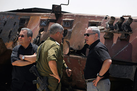 Il primo ministro isaeliano Benjamin Netanyahu (a destra) e il ministro della Difesa Ehud Barak di fronte a un veicolo militare egiziano bruciato,appena fuori dal Sud della Striscia di Gaza il 6 agosto 2012 (Foto: Reuters/VostokPhoto)