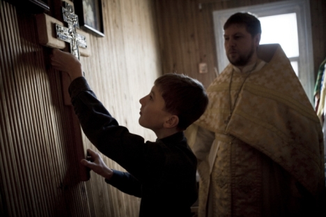Fedor aiuta suo padre, prete ortodosso, durante il servizio della domenica, nel villaggio di Bagan, nella regione di Novosibirsk, 2011 (Credit: Valerij Klamm)