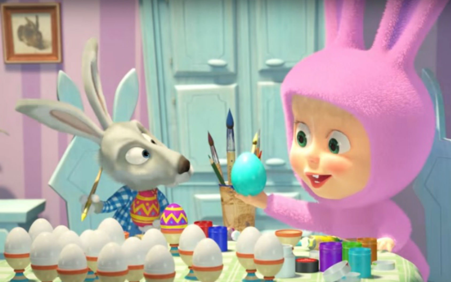 Masha dan kelinci sedang mewarnai telur-telur Paskah.