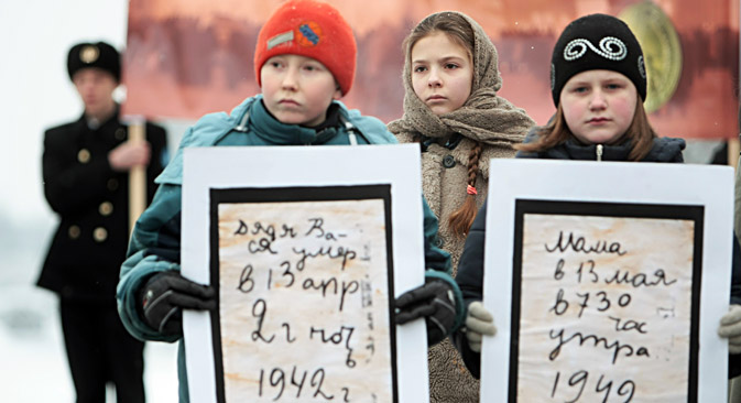 レニングラード解放７０周年にちなむキャンペーン「封鎖のパン」で、子供の参加者らが、ターニャ・サヴィチェワの日記の抜粋と写真を持っている。＝ウラジーミル・ジェルノフ/ロシア通信撮影