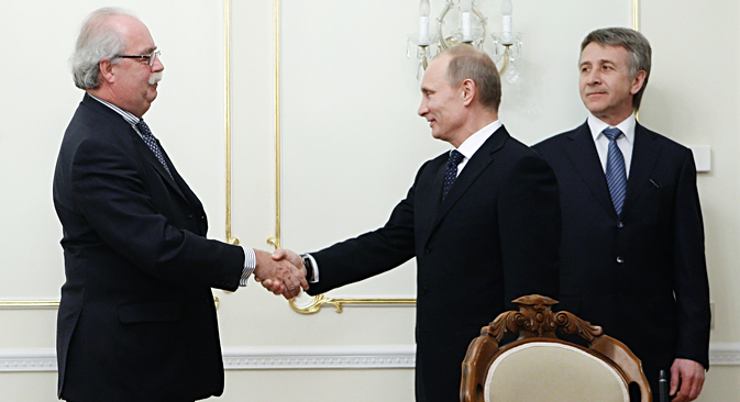 2011年3月2日、プーチン首相（当時）が、モスクワ郊外のノボ・オガリョボの官邸で、仏石油大手「トタル」のクリストフ・ドマルジュリ最高責任者（CEO）を歓迎する。その様子を、ロシア最大の独立系天然ガス生産・販売会社「ノバテク」のレオニード・ミヘリソンCEO（右）が見ている。ノバテクとトタルの協力に関する覚書調印の席で。＝AFP/East News撮影