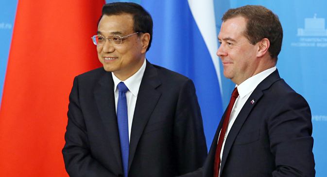 ロシアのメドベージェフ首相と訪露した中国の李克強首相（左）がモスクワでの会談後、最後の記者会見前に握手する。＝AP通信
