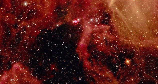 Остаци супернове SN1987A (сјајно поље са два црвена прстена изнад центра). Фотографија телескопа „Хабл“, слободни извори.