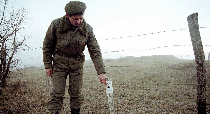Офицер на Југословенската армија покрај радиоактивно поле во село Рељина кај Прешево, 7 јануари 2001 година. Извор: Ројтерс.