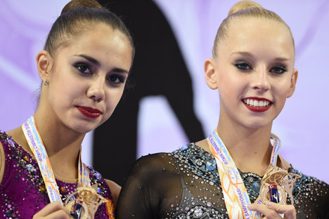 Маргарита Мамун и Јана Кудрјавцева са златним медаљама које су освојиле на Светском првенству 2014. у Измиру. Извор: РИА „Новости“.
